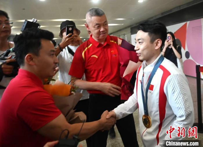 成都机场迎接巴黎奥运会双杠冠军邹敬园归来，